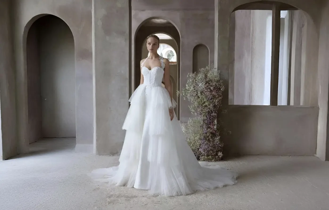 Bride and groom walking hand in hand in a garden.