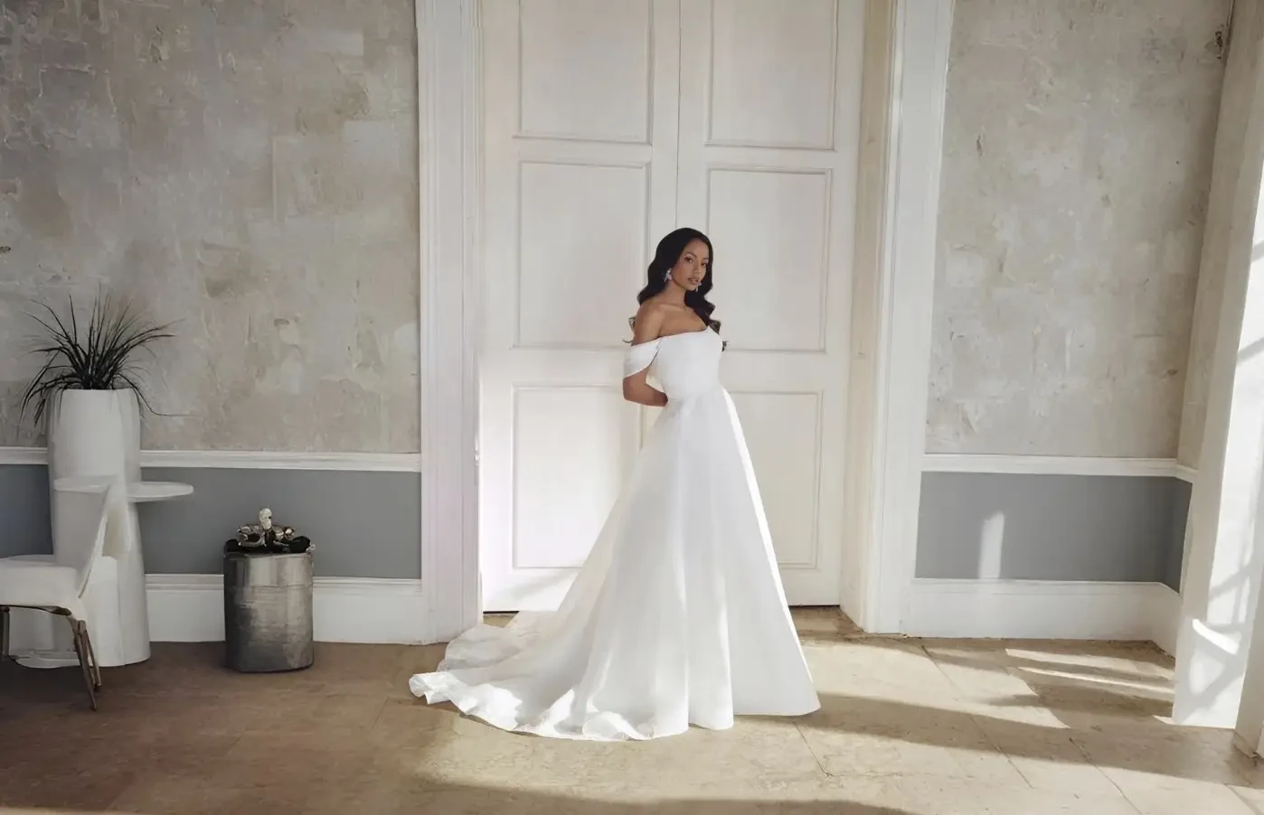 Bride and groom walking hand in hand in a garden.
