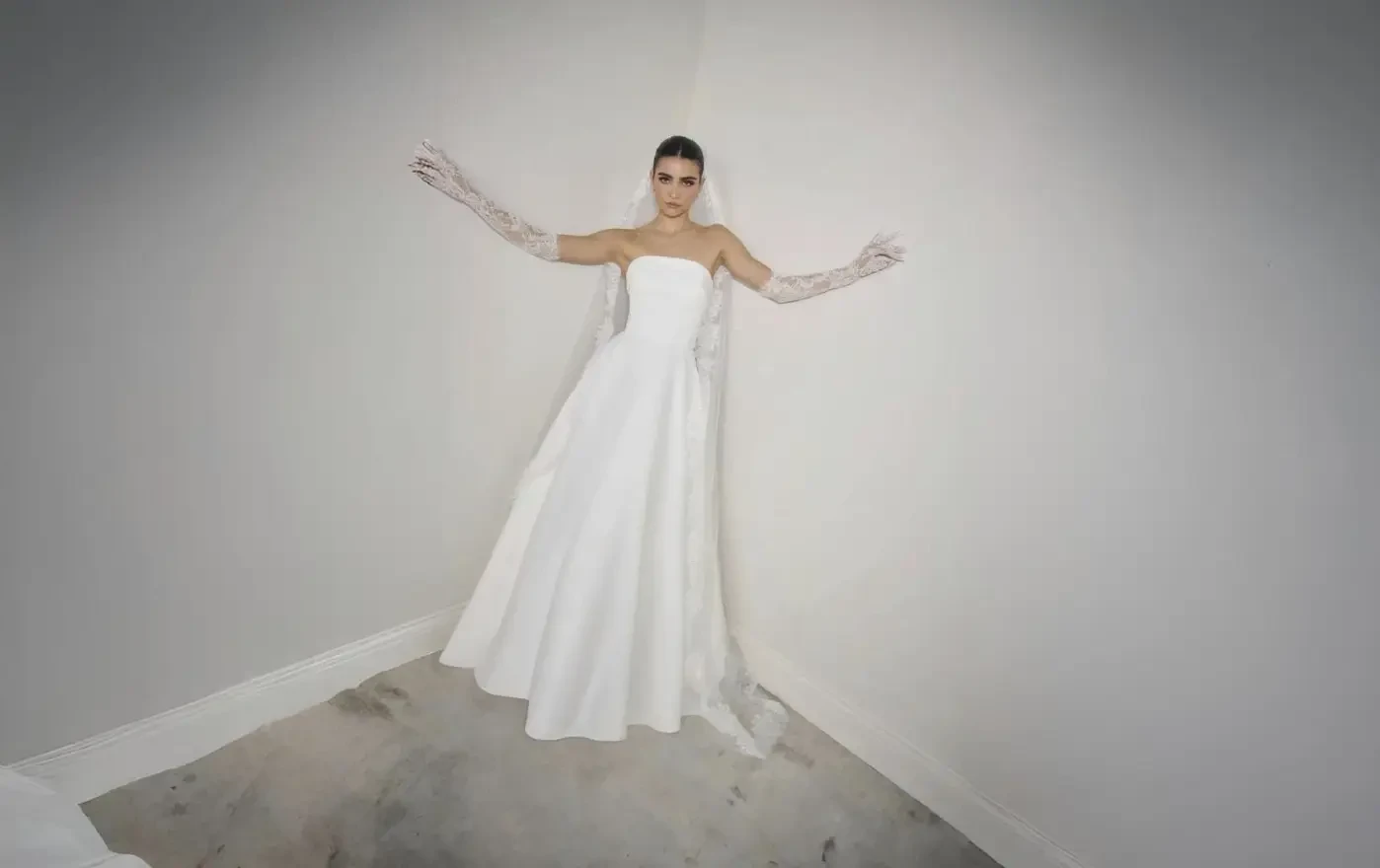 Bride and groom walking hand in hand in a garden.