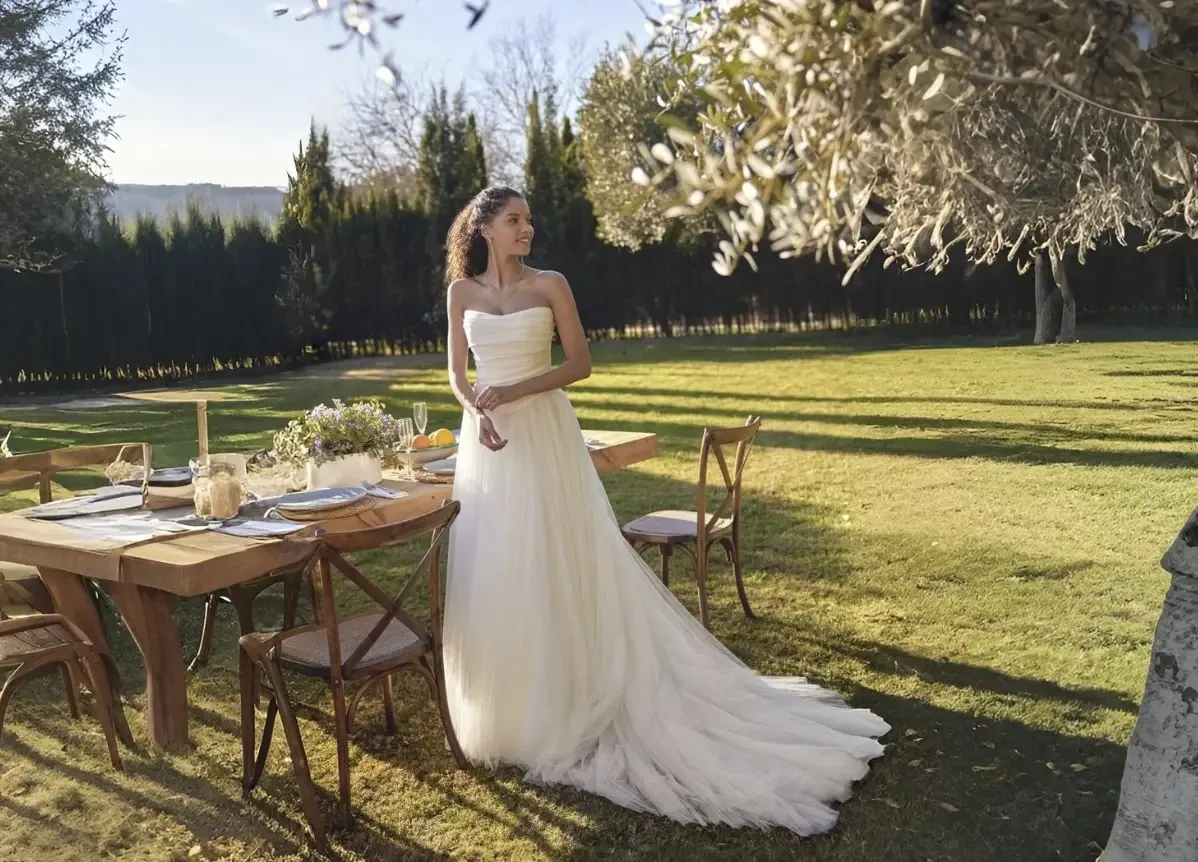 Bride and groom walking hand in hand in a garden.